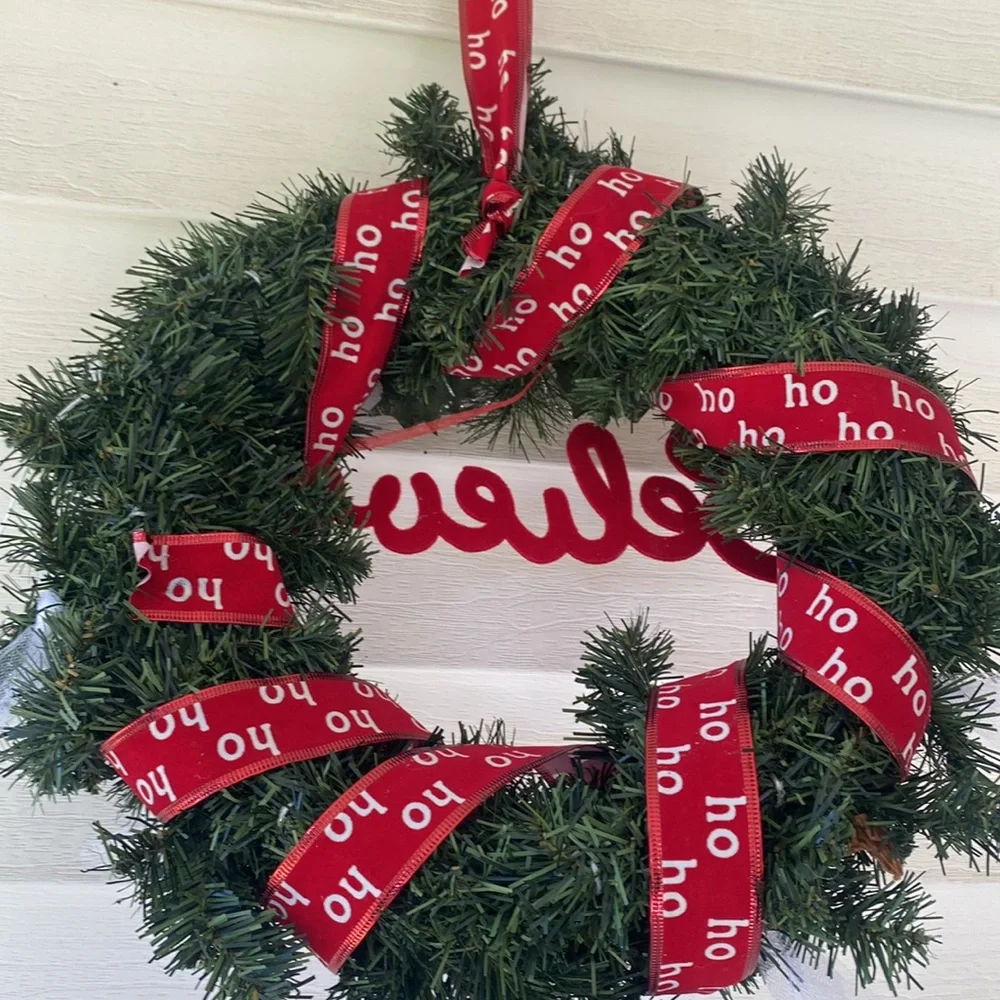 Believe evergreen faux wreath trimmed with the word believe and ho ho ho ribbon